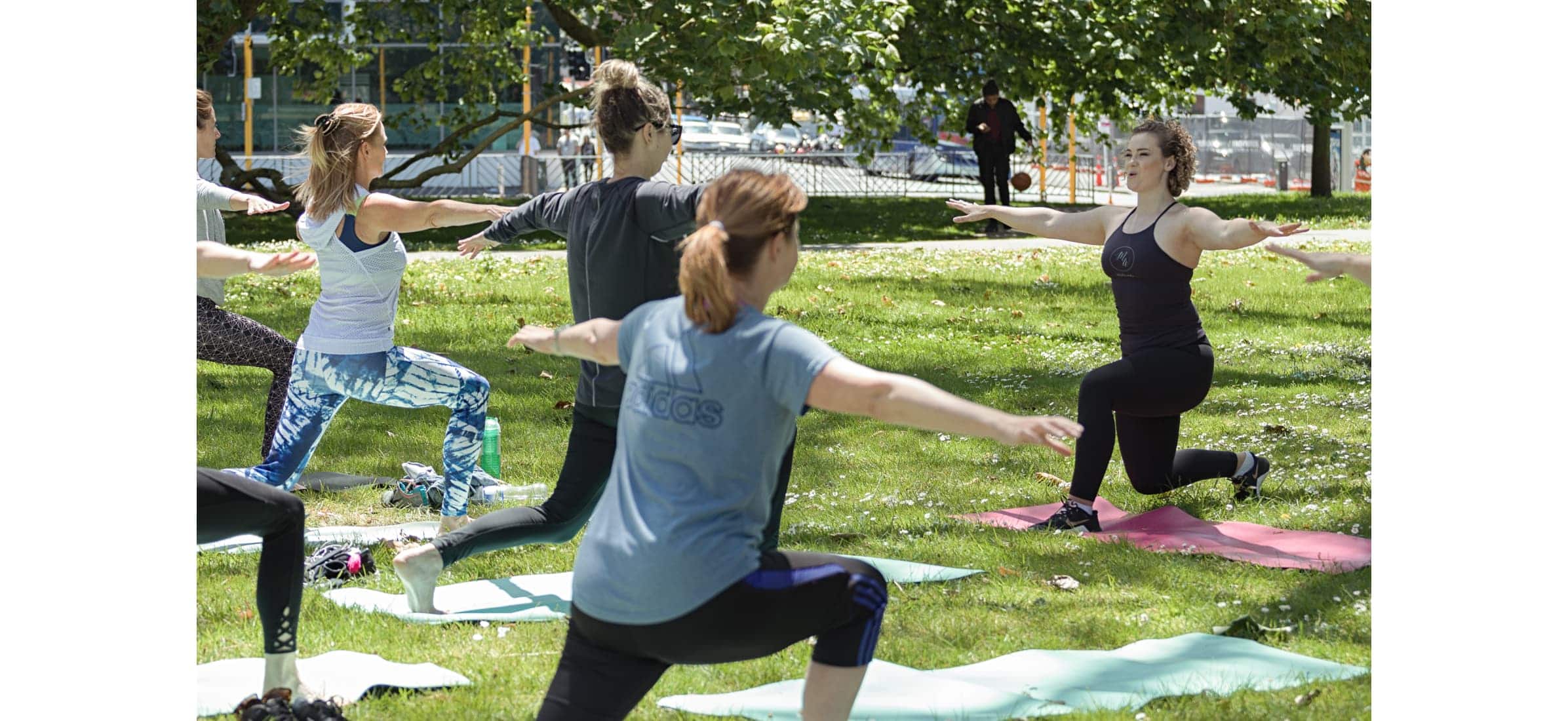 Phoebe Heyhoe from MatWorks Pilates leading a pilates class in a park.